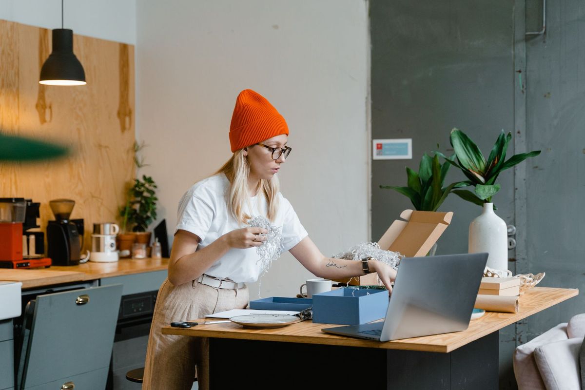 Shop-Inhaberin arbeitet im Homeoffice am Laptop an ihren Bestellungen